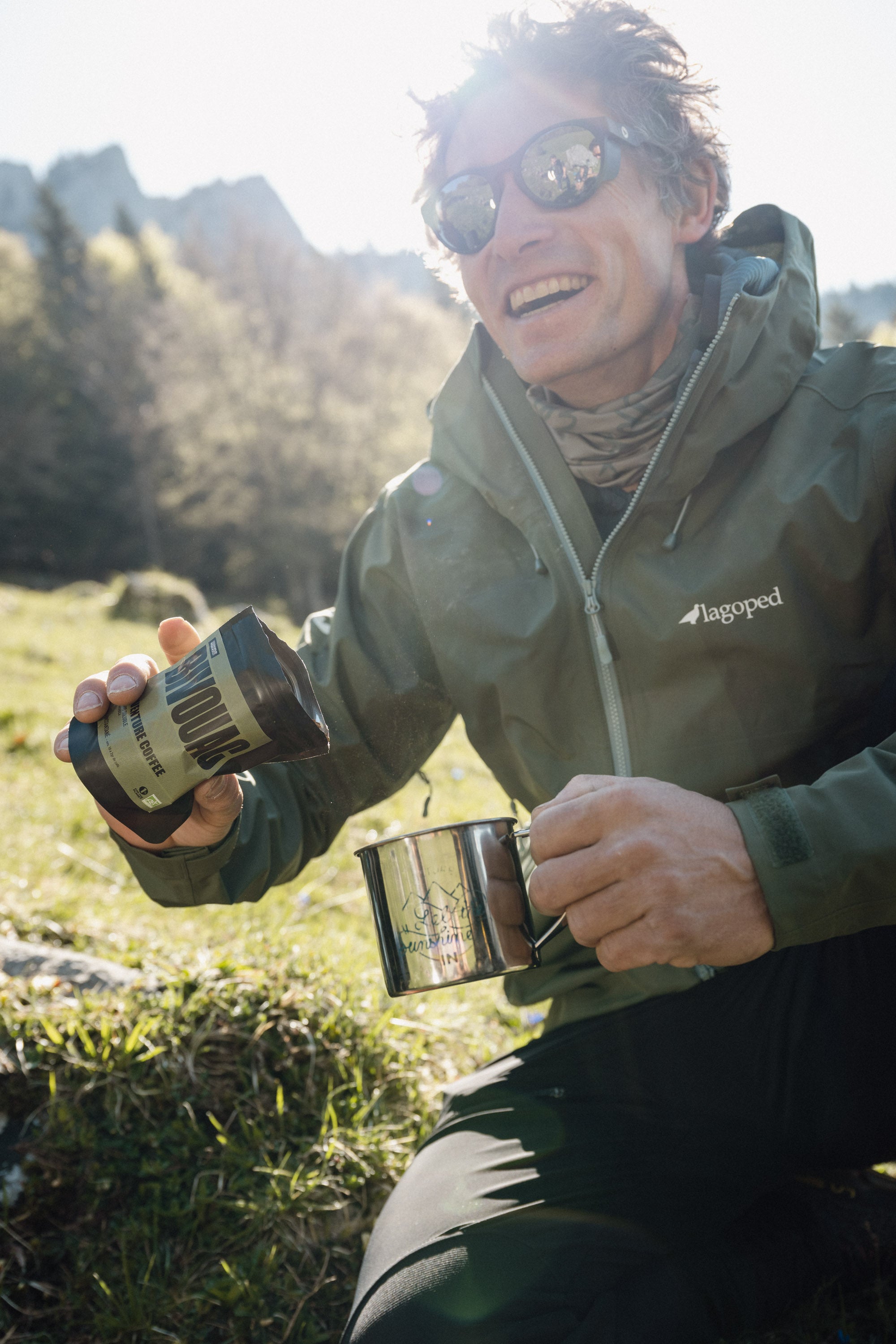 Homme portant la veste softshell Ukpik Lagoped lors d'une randonnée en alpage printanier