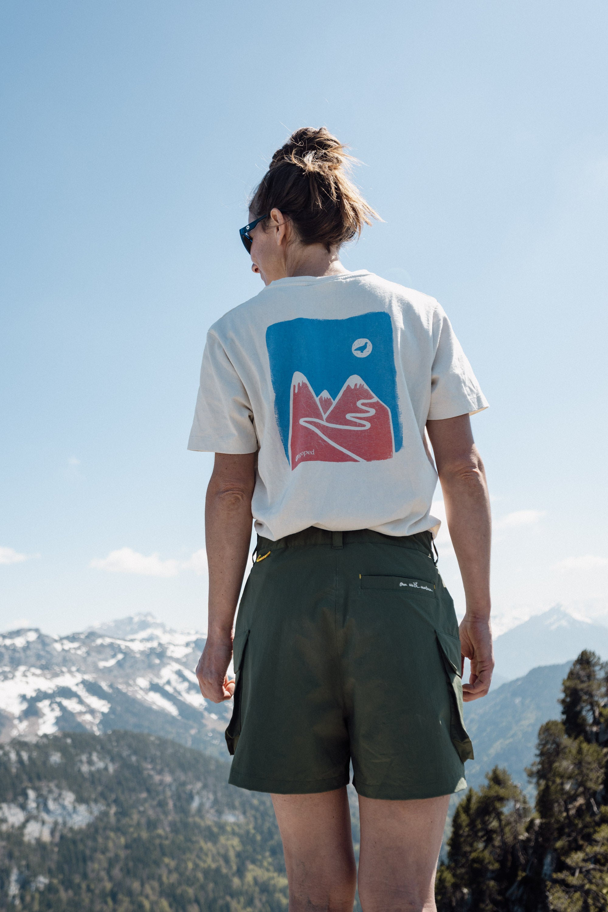 Femme portant le short de randonnée Nyeles Lagoped dans un paysage alpin printanier