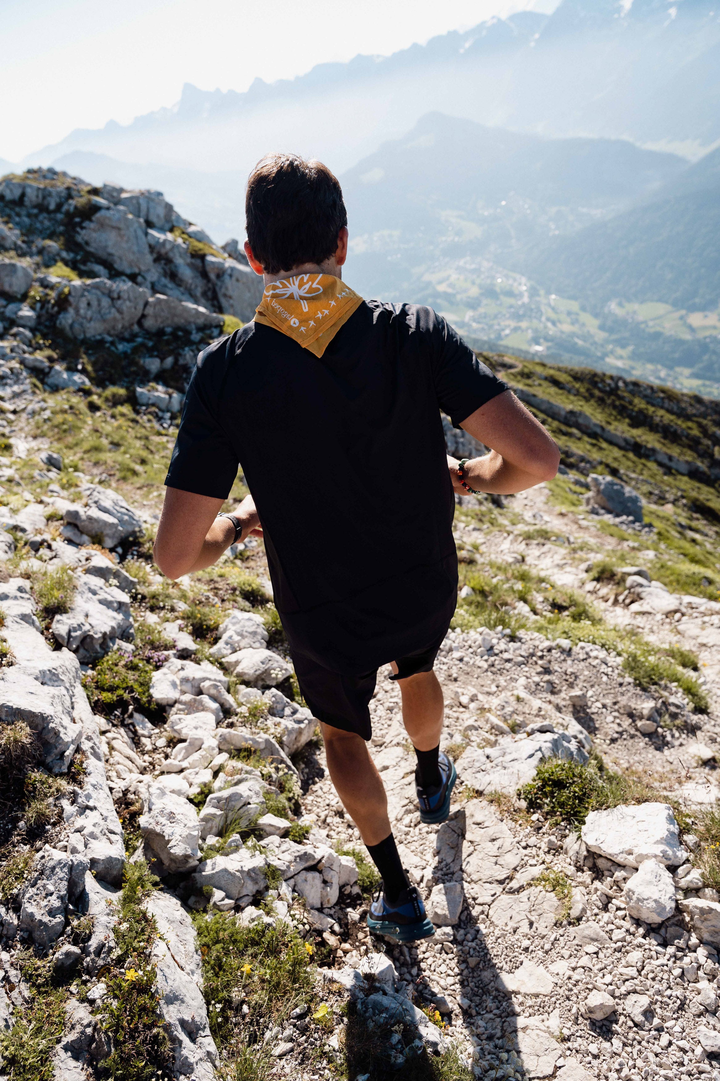 Personne portant un foulard Lagoped Heron jaune soleil, course à pied en été dans les Alpes