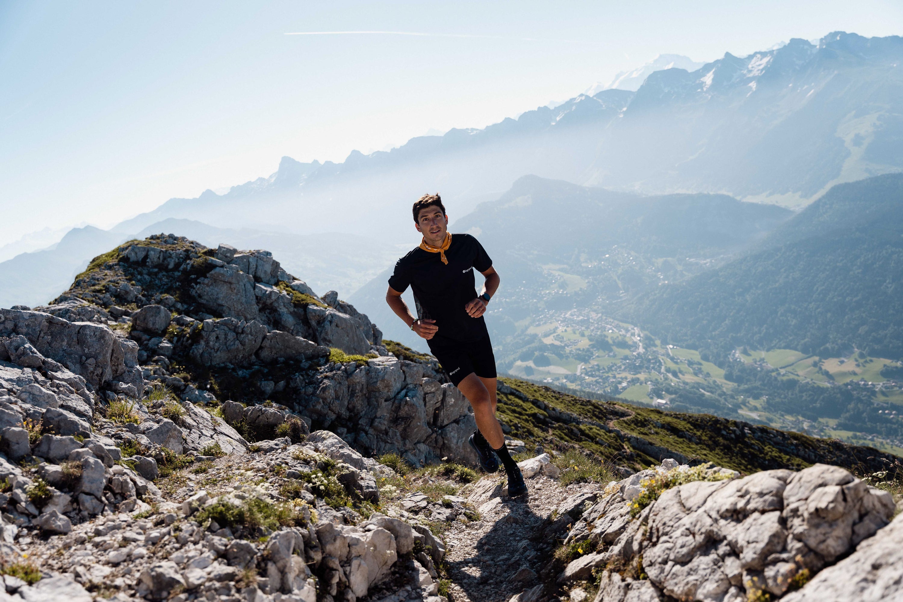 Personne portant un foulard Lagoped Heron jaune soleil, trail running en été dans les Alpes
