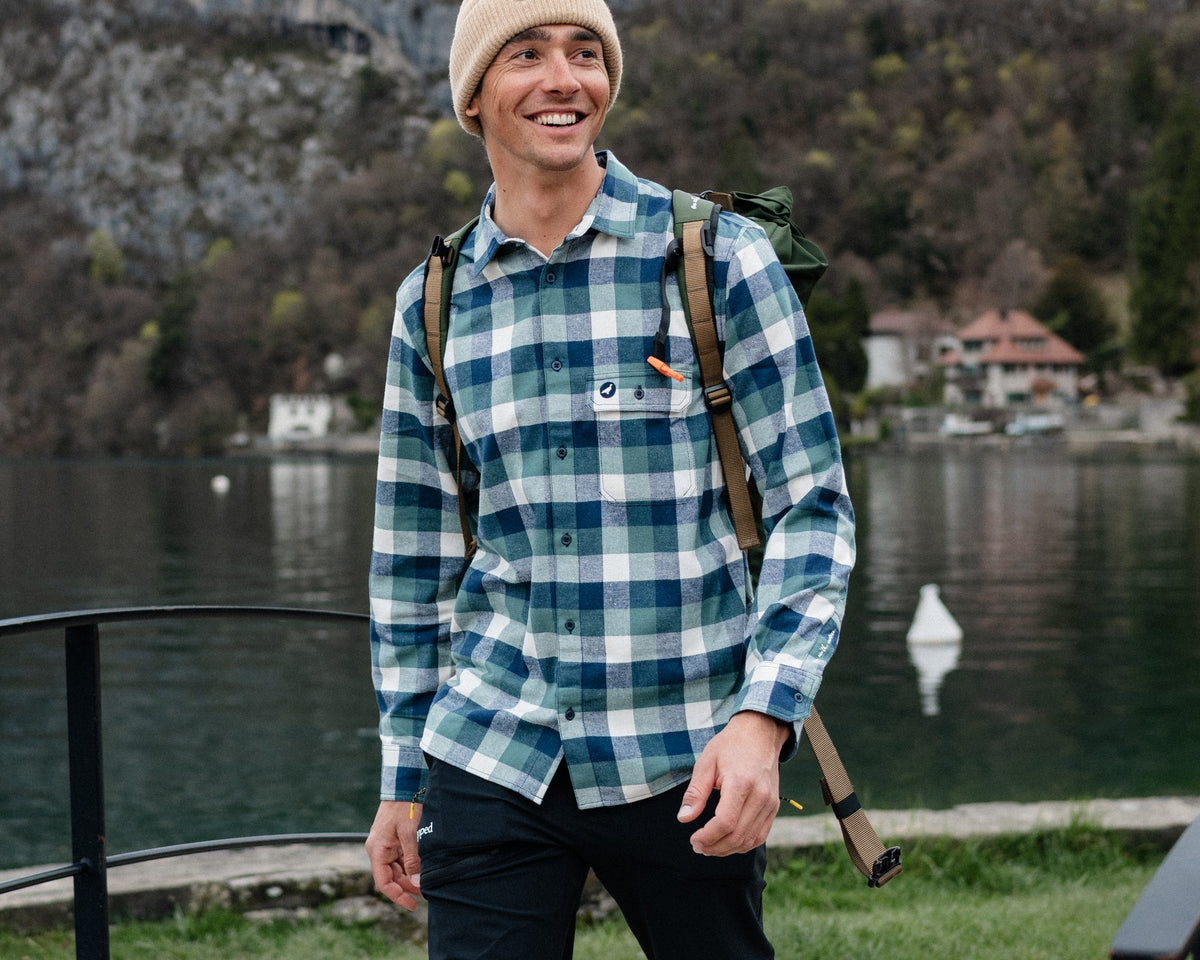 Homme en randonnée au bord du lac portant la chemise flanelle Lagoped PERDIZ navy verde, sac à dos sur l'épaule