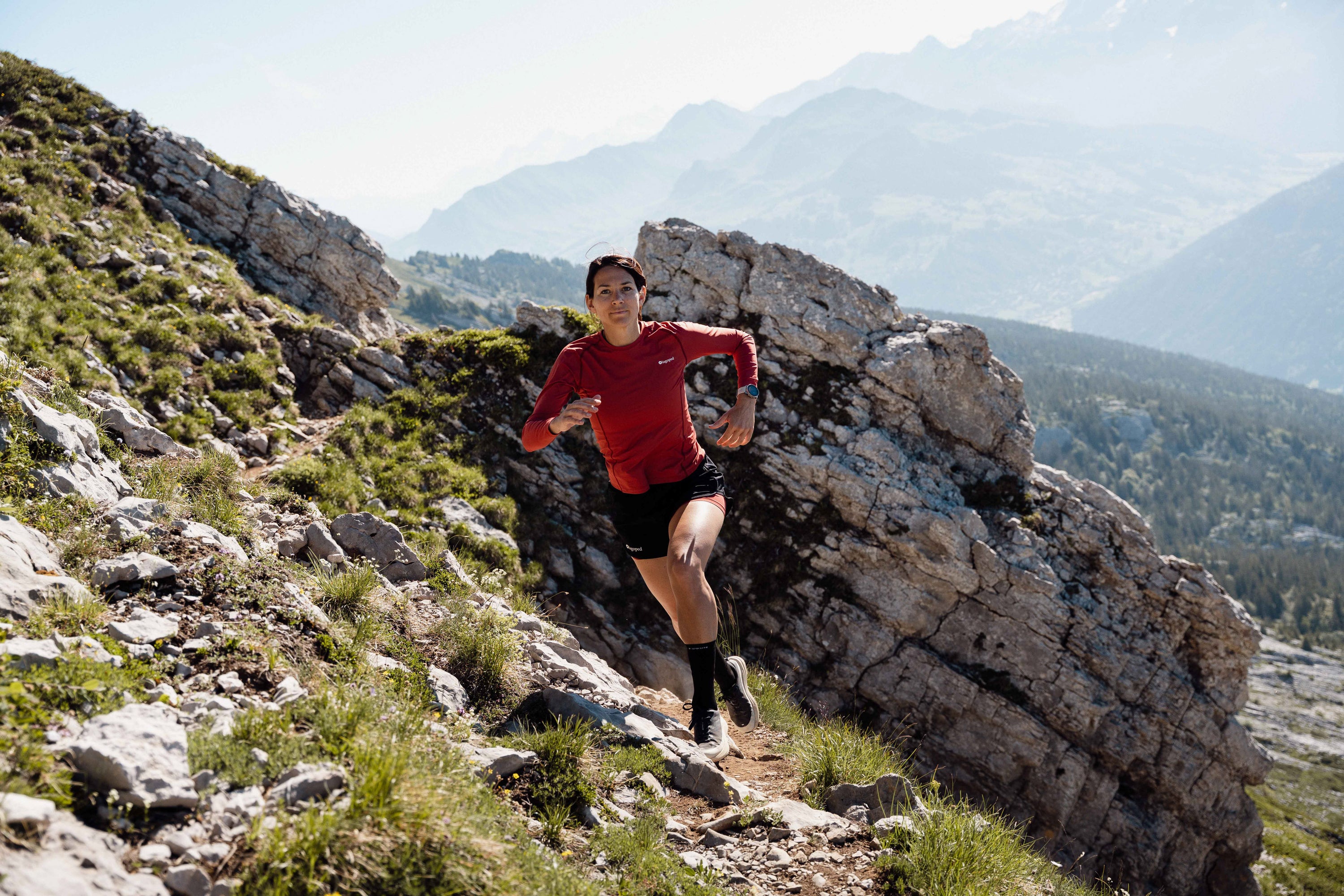 Femme portant un t-shirt Lagoped Roka rouge, randonnée en demi-saison dans les Alpes