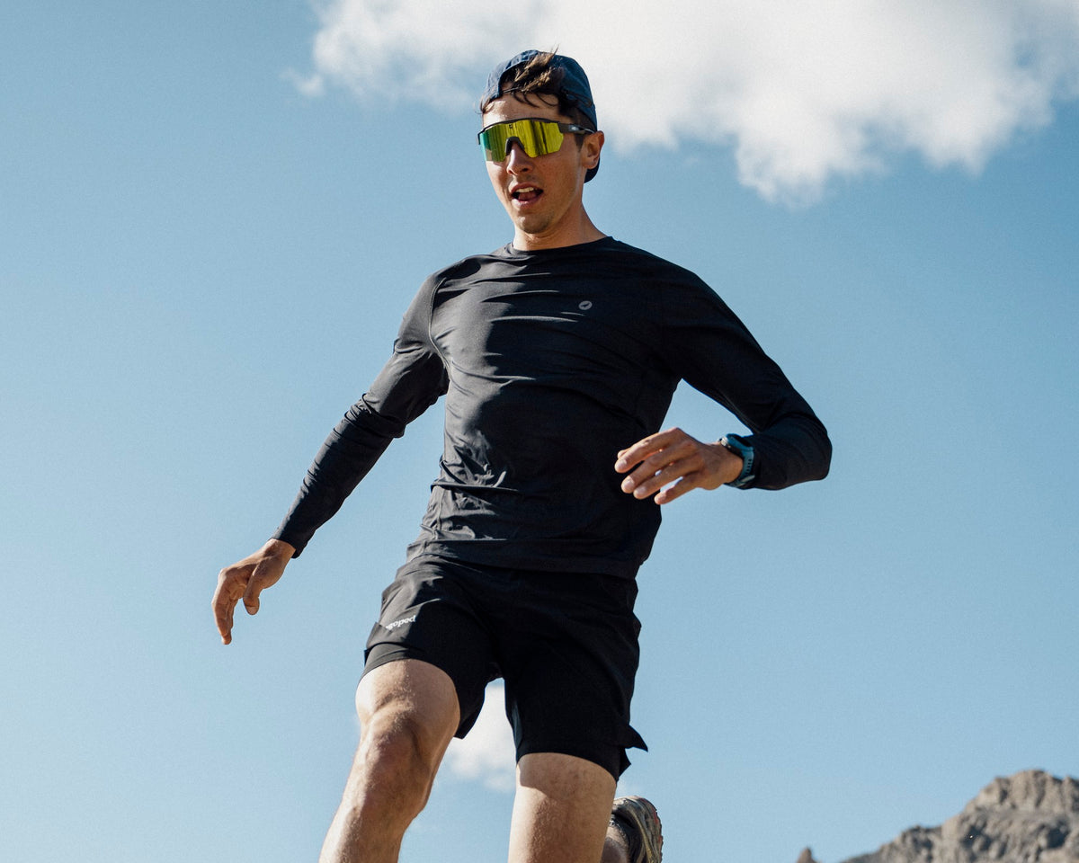 Homme en trail dévalant un sentier de montagne en pleine foulée, portant le t-shirt technique Lagoped ROKA graphite