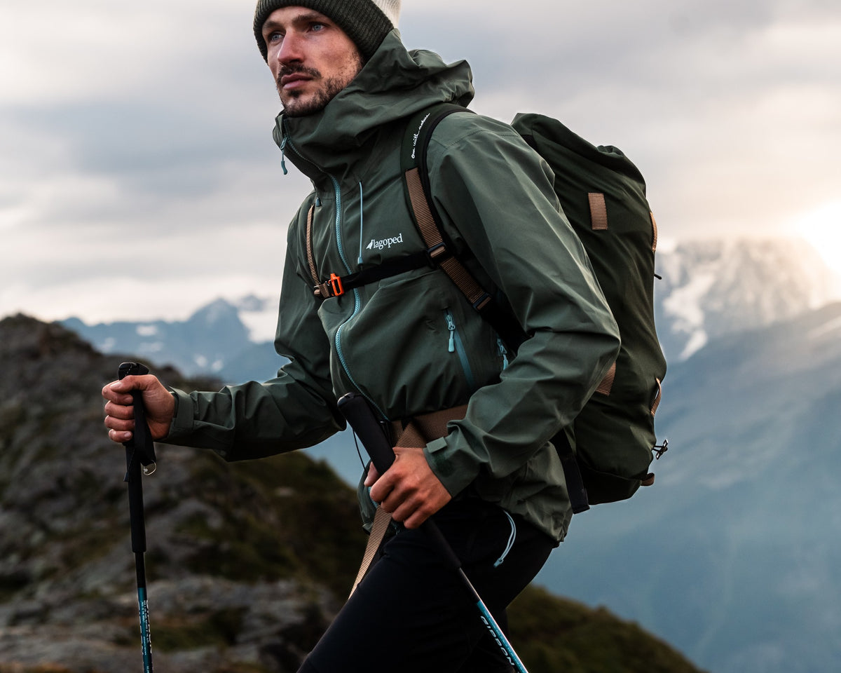 Homme en randonnée avec bâtons portant la veste rando-montagne Lagoped TETRAS thym, en été en montagne