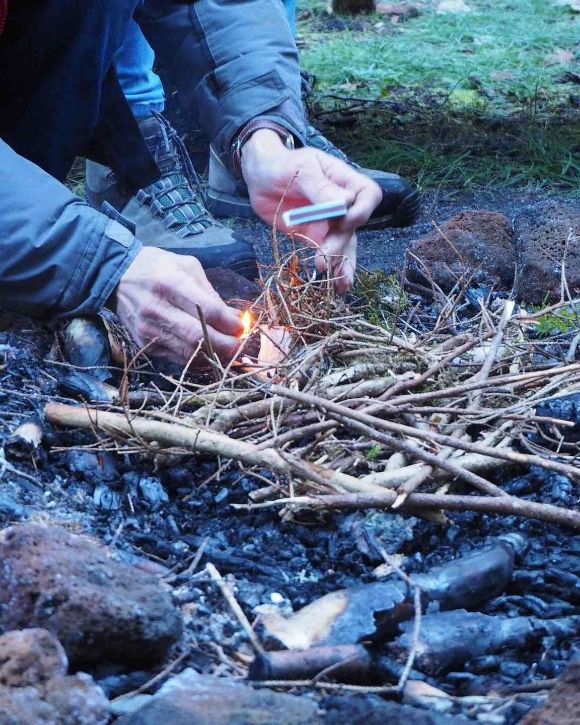 Mains disposant du petit bois pour démarrer un feu de camp